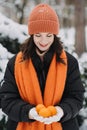 Woman smiling in snowy forest, holding oranges. Winter wellness trends, vitamin C boost, cozy health rituals, immune