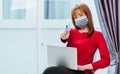 Woman smiling, student girl working with laptop computer at home office and show alcohol spray sanitizing on hand Royalty Free Stock Photo