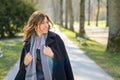 Woman smiling to herself as she strolls through a spring park