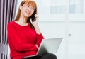 Woman smiling using mobile phone call director to team during working with laptop computer at home office Royalty Free Stock Photo