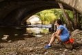 Woman smokes while sitting alone under a bridge Royalty Free Stock Photo