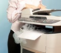 Woman with smoking copier at office