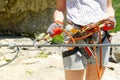 the woman snaps the safety carabiner on the cable. Climber in a cliff ties a security knot