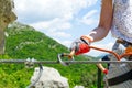 the woman snaps the safety carabiner on the cable. Climber in a cliff ties a security knot