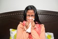 Woman sneezing into a tissue in the room Royalty Free Stock Photo