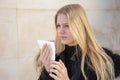 Woman sneezing in winter with hanky in hand