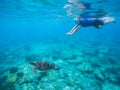 Woman snorkeling with green turtle underwater photo. Royalty Free Stock Photo