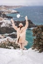 Woman snow sea. Amidst a wintry backdrop, a woman in a beige faux fur coat gleefully engages in a snowball fight, adding