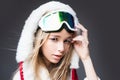 Woman snowboarder in ski clothing poses with a ski goggles. Portrait of young girl with snow goggles. Royalty Free Stock Photo