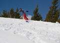 Woman snowboarding down snowy hill in the mountains