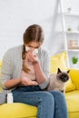 Woman with snuffle looking at pills