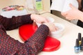 Woman Soaking Hands in Water During Manicure