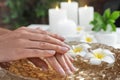 Woman soaking her hands in bowl of water and flowers. Spa treatment Royalty Free Stock Photo