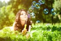 Woman and soap bubbles in park. Beautiful young girl lying on th Royalty Free Stock Photo