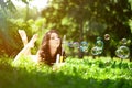 Woman and soap bubbles in park. Beautiful young girl lying on th Royalty Free Stock Photo