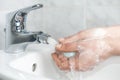 Woman soap her hand under a faucet with running water