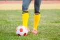 Young woman soccer player kicks ball on football field Royalty Free Stock Photo