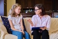 Woman social worker talking to baby girl, meeting session at home on sofa Royalty Free Stock Photo