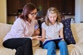 Woman social worker talking to baby girl, meeting session at home on sofa Royalty Free Stock Photo