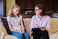 Woman social worker talking to baby girl, meeting session at home on sofa Royalty Free Stock Photo