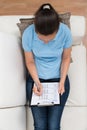 Woman On Sofa Filling Survey Form Royalty Free Stock Photo