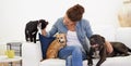 Woman, sofa and happy with pet, cat and dog for care, love and bonding in home living room, playing and together. Girl Royalty Free Stock Photo