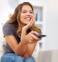 Woman, sofa and tv with remote and relax in home, smile and watching for weekend. Media, online and comedy movie or