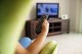 Woman on sofa watching tv changing channel with remote Royalty Free Stock Photo