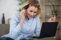 woman on sofa wearing headset and using laptop Royalty Free Stock Photo