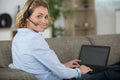 woman on sofa wearing headset and using laptop Royalty Free Stock Photo