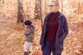 Woman with son in the autumn forest on a walk. Girl in the woods.