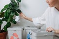 Woman sorting garbage, throwing a piece of crampled paper in a small recycle bin Royalty Free Stock Photo