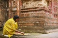 Woman sorts corn at Pancharatna Govinda temple in Puthia, Bangladesh.