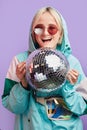 Woman with sparkling disco ball, dressed in trendy mint and pink windbreaker. Royalty Free Stock Photo