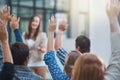 Woman speaker at conference, group of people with hands up for question or answer at training presentation or meeting