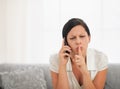 Woman speaking mobile phone and showing shh Royalty Free Stock Photo