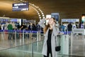 Woman talking by smartphone and looking for friend at aiport. Royalty Free Stock Photo