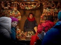 A woman stands behind the counter in the Illuminated Christmas fair kiosk with new year decorations in Vienna, Austria