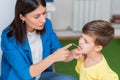 Woman speech therapist corrects speech defects in a boy in her office