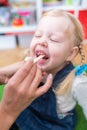 Woman speech therapist helps little girl to correct her speech in her office