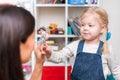 Woman speech therapist helps little girl to correct her speech in her office