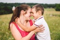 Woman spends time with a child in nature. Mother and son embracing in the park. Happy mom playing with her boy in the field on a Royalty Free Stock Photo