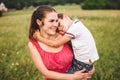 Woman spends time with a child in nature. Mother and son embracing in the park. Happy mom playing with her boy in the field on a Royalty Free Stock Photo