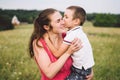 Woman spends time with a child in nature. Mother and son embracing in the park. Happy mom playing with her boy in the field on a Royalty Free Stock Photo