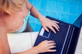 Woman spends time, has relax and work with laptop on the pool. People, summer and holiday concept Royalty Free Stock Photo