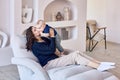 Woman spends time with infant on sofa in living room.