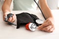 Woman with sphygmomanometer, stethoscope and red heart at white table Royalty Free Stock Photo