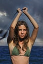 Woman spinning poi on the beach.