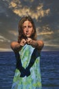 Woman spinning poi on the beach.