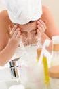 Woman splashing water face in bathroom